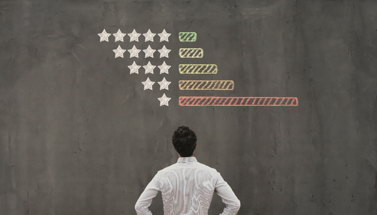 Person standing in front of a chalkboard with start ratings drawn on it