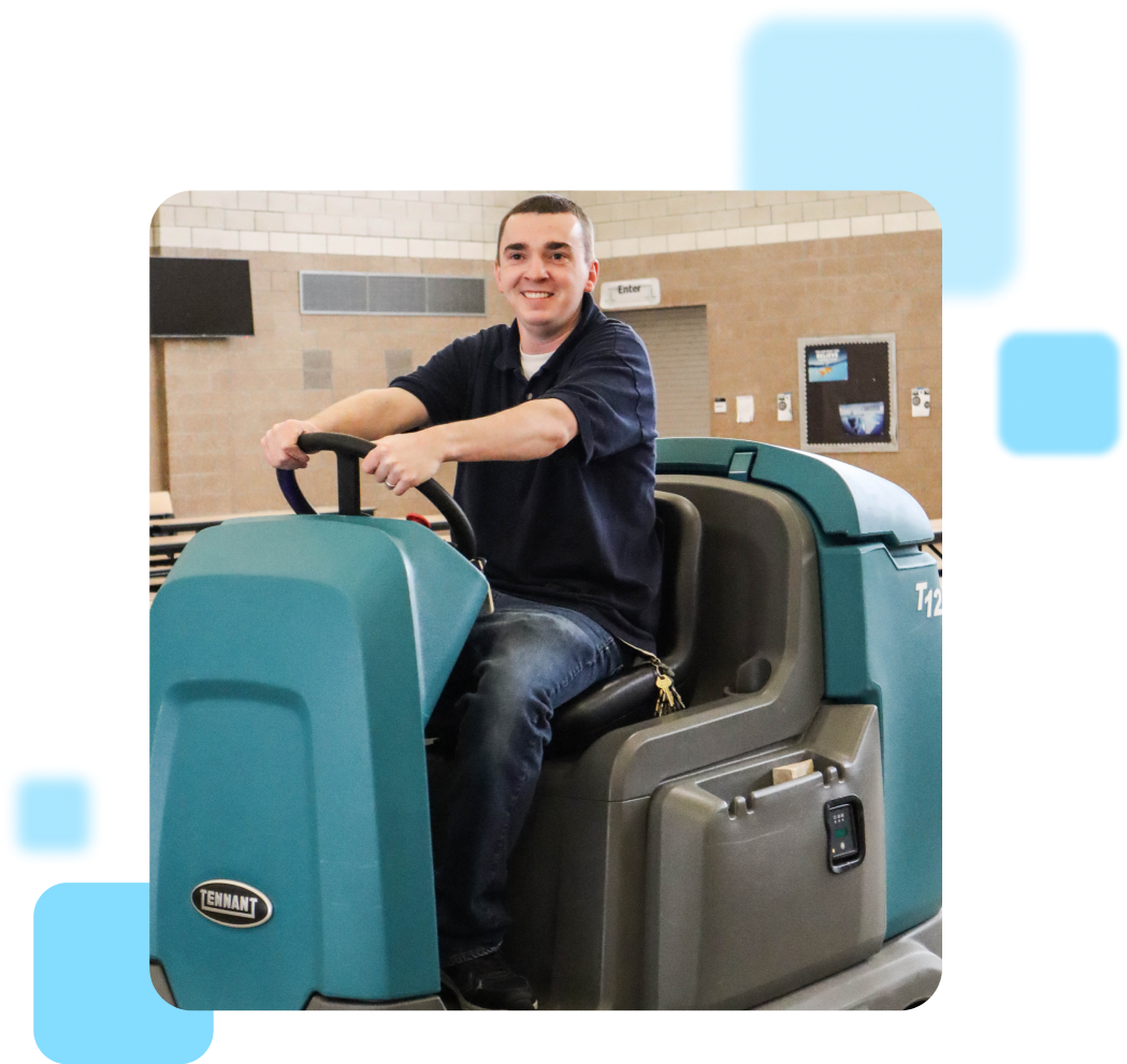 Person smiling and operating a Tennant cleaning machine