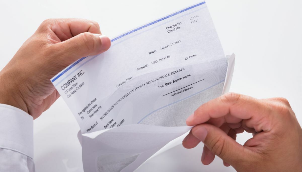 person opening envelopes with a check inside