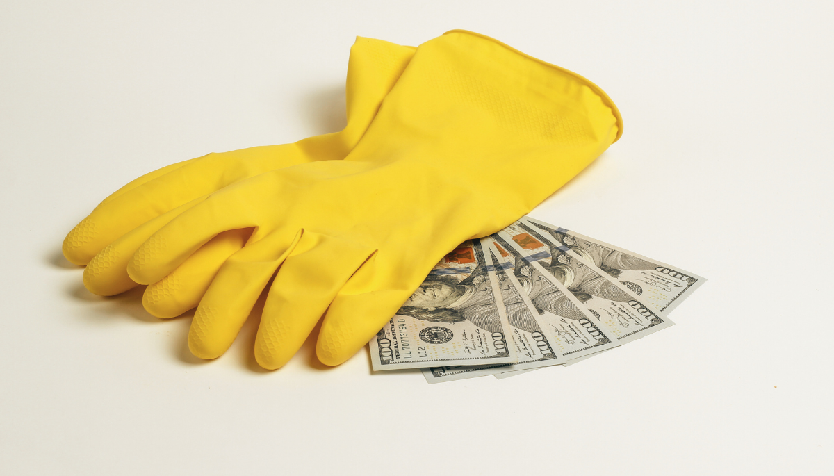 pair of yellow rubber gloves laying on money